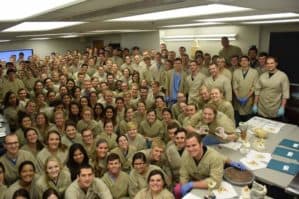 Group photo of an M1 class wearing gross anatomy lab coats and scrubs.