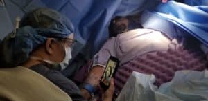 Surgical staff using Facetime on a phone with a patient