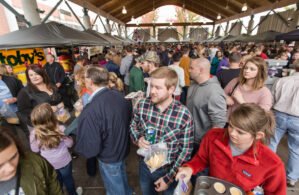 large group of people in a pavilion during the cheese dip championship