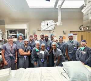 Group photo of residents in a procedure room. They are wearing scrubs.