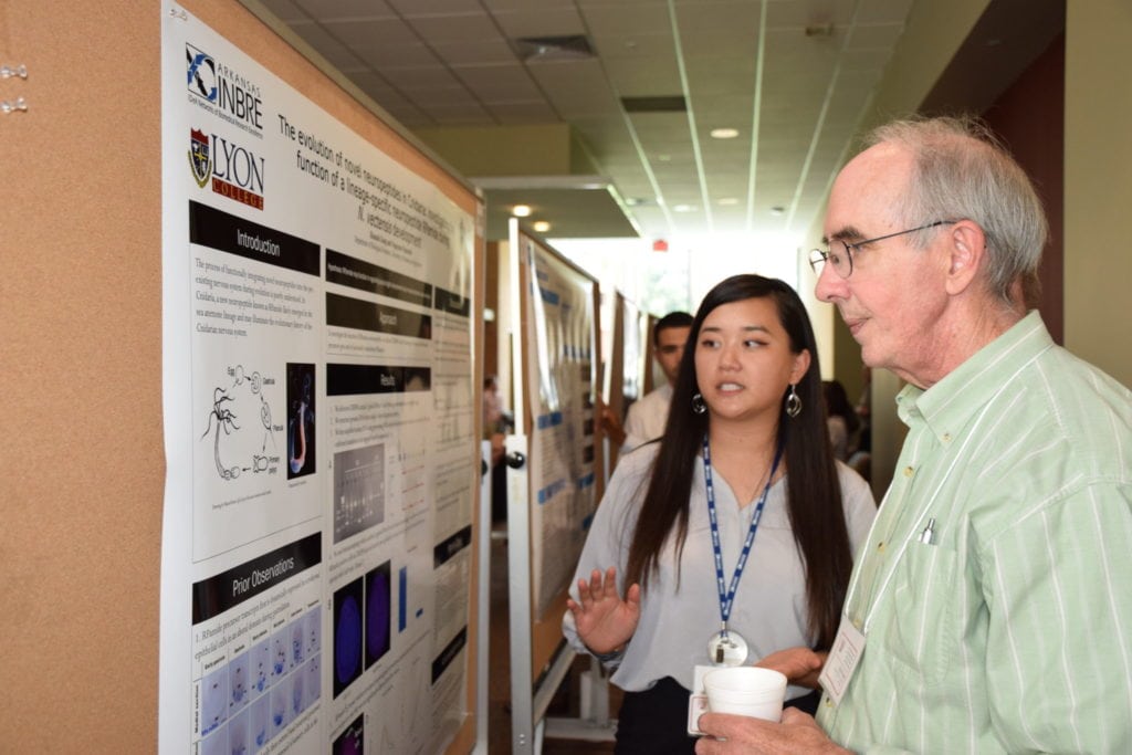 student presenting research to faculty member