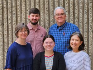 Five members of the Wahls lab standing in front of a wall.