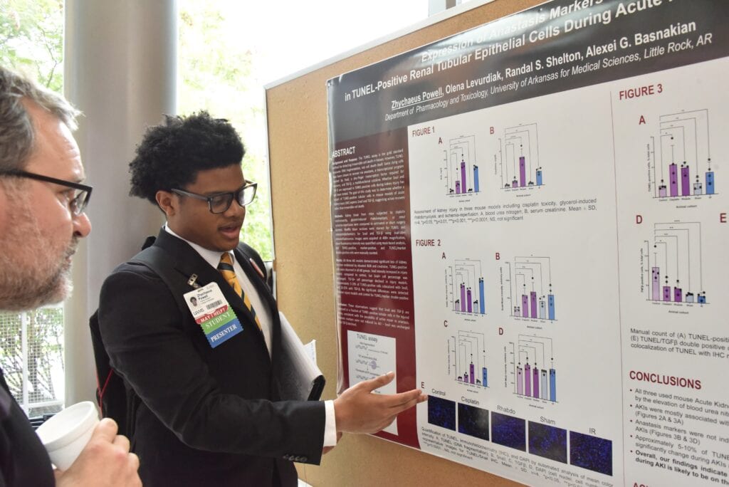 A student presenting their poster