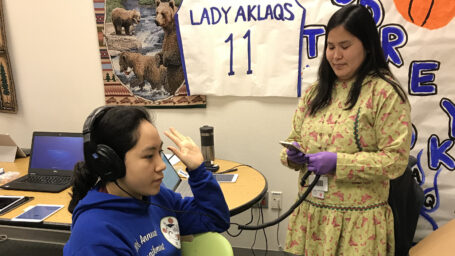 Women doing hearing screen with a student in a classroom