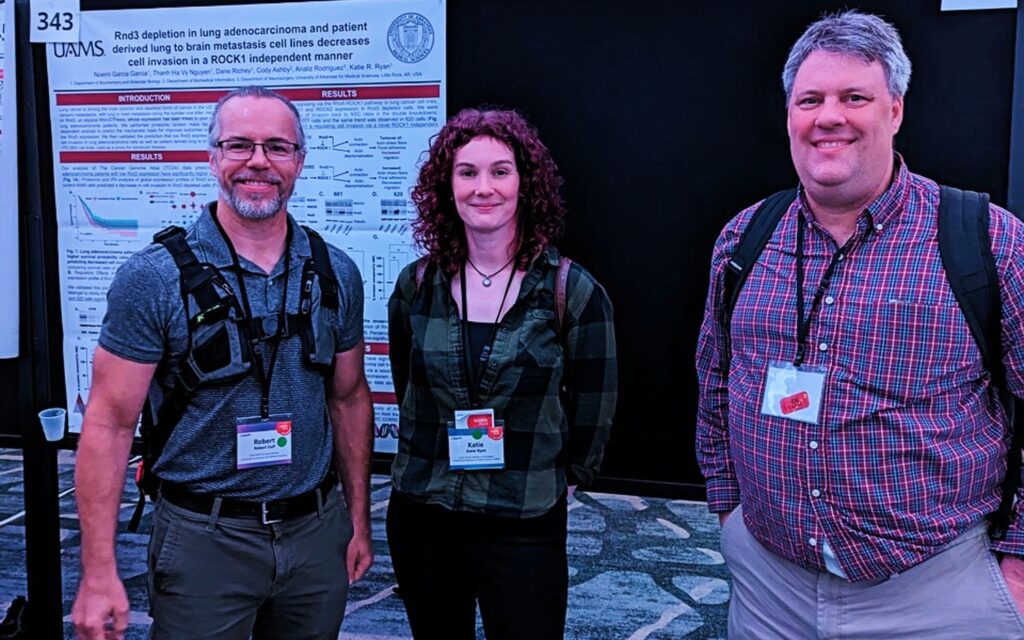 Drs. Eoff, Ryan and Enemark posing in front of a scientific poster.