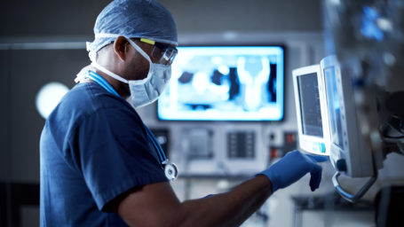 Shot of a surgeon looking at a monitor in an operating room