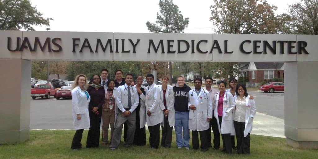 Residents posing under the Family Medical Center sign