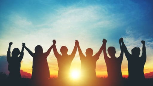 Silhouette of group business team making high hands over head in sunset sky evening time for business success and teamwork concept in company growth mergers and acquisitions start greeting etiquette
