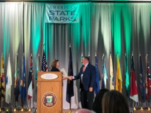 Cindy Deblauw, physical activity and nutrition program manager with Missouri Dept. of Health and Senior Services, shakes hands with Peter Mayer, Washington State Parks director, after winning the 2021 Healthy Parks Award.