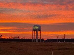 Crossett water tower at dusk with orange colored clouds behind