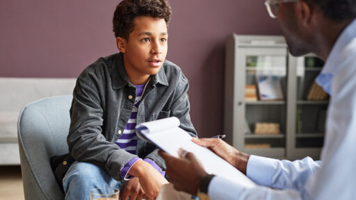 Teen boy talking to provider in clinic setting