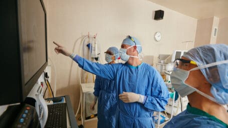 Shot of a team of surgeons discussing a patient’s medical scans during surgery