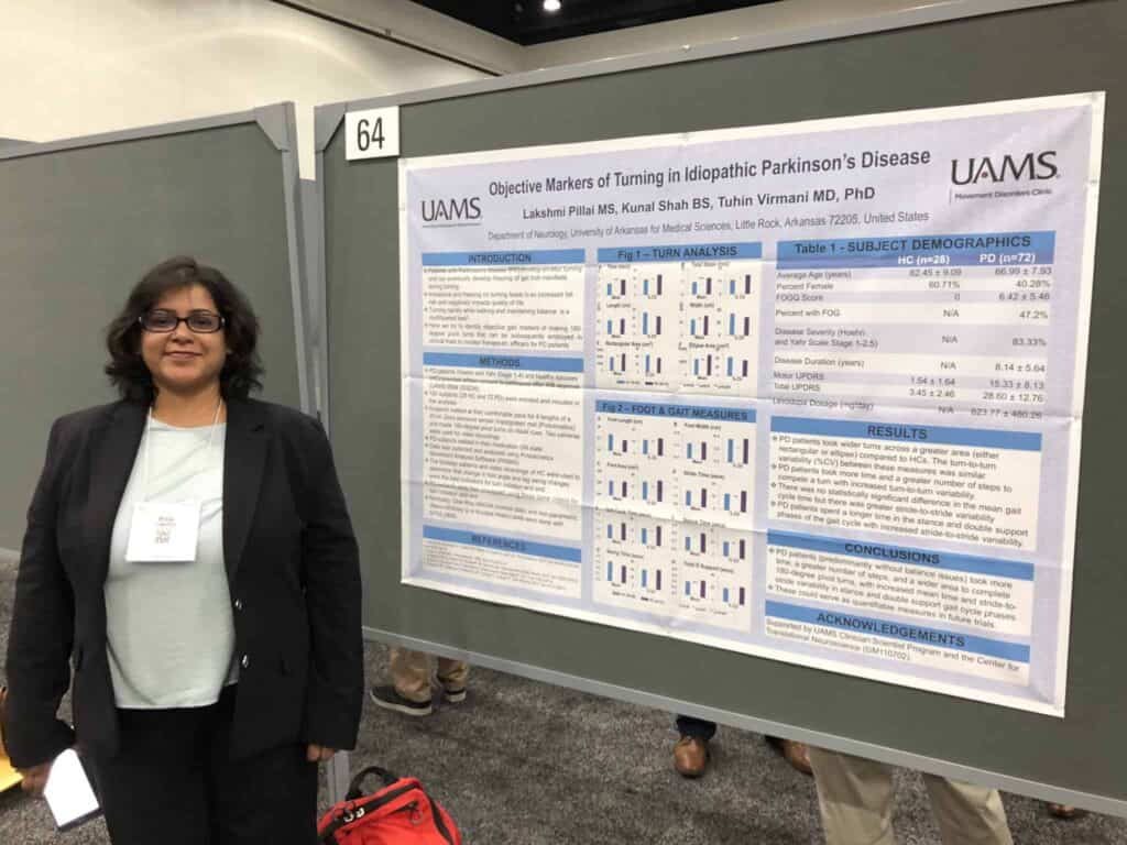 Researcher standing next to poster