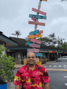 Rohan Sharma posing by sign on vacation