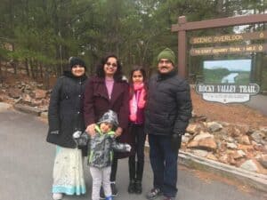Nayana Prabhu and family in front of travel sign