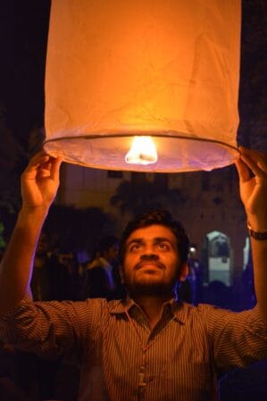 Dr. Javed holding a large lit paper lantern