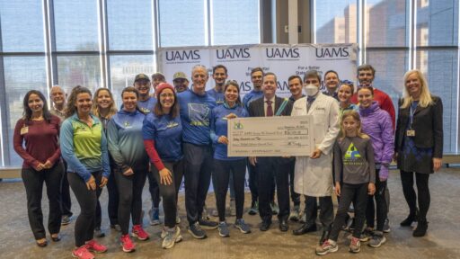 Pictured with the Rampy MS Research Foundation relay team and and UAMS’ MS research team, Jo and Scott Rampy present Cam Patterson, M.D., MBA, and Rohit Dhall, M.D., with the relay baton containing the check.