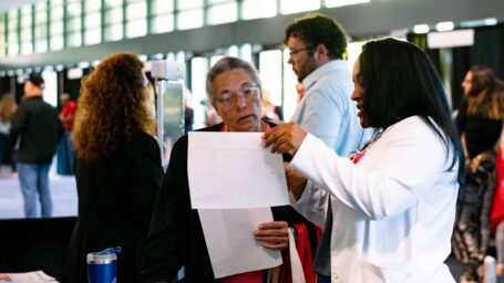 A person shows information to attendees at the Stroke Conference