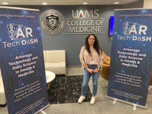 Sandra Perez poses next to AR Tech Dash banners