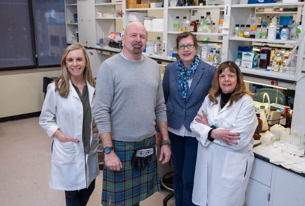 Faculty researchers posing in a scientific lab