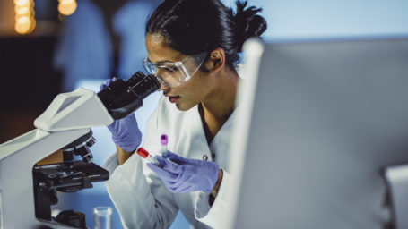 Young Scientist Looking Through a Microscope