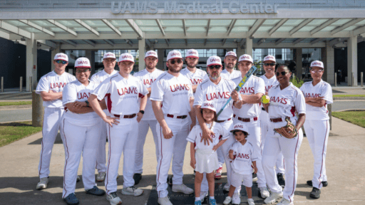 Members of the UAMS Department of Neurosurgery softball team pose before the tournament, with Sophia and Santiago, the son and daughter of coach Hector Soriano, M.D. Image by Bryan Clifton