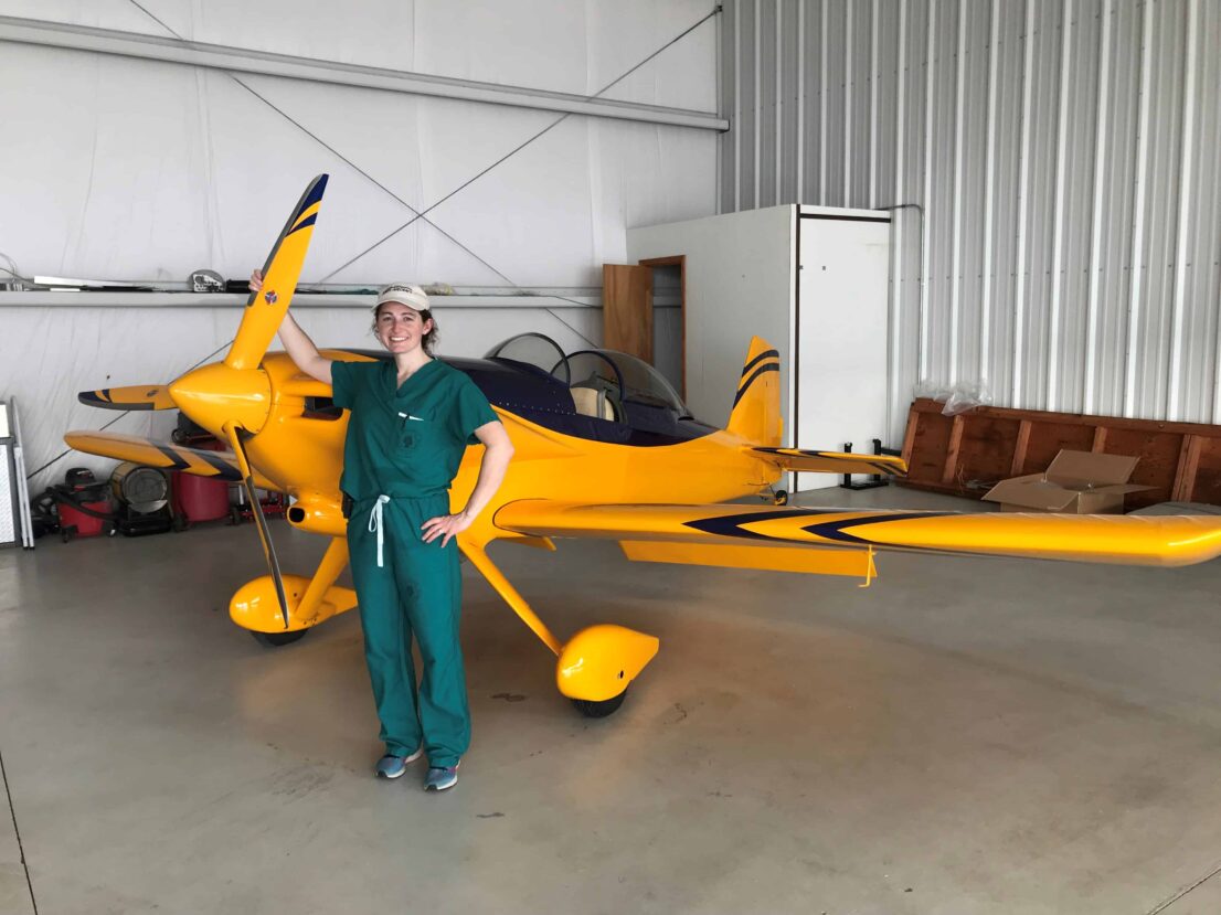 resident posing with a yellow small airplane