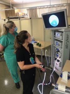 residents working on a laproscopic simulation