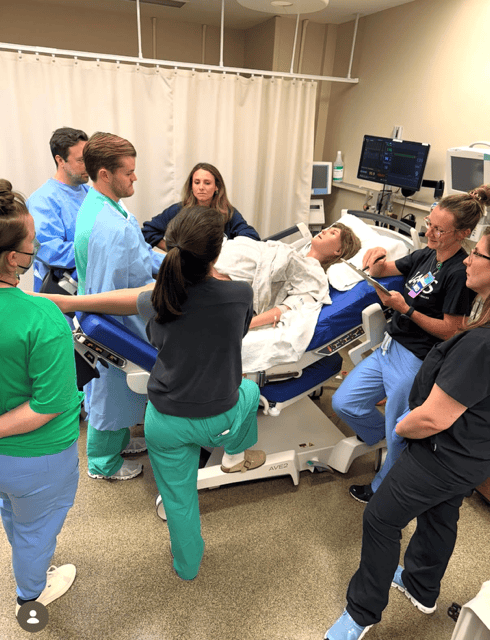 a group of residents participating in birthing simulation