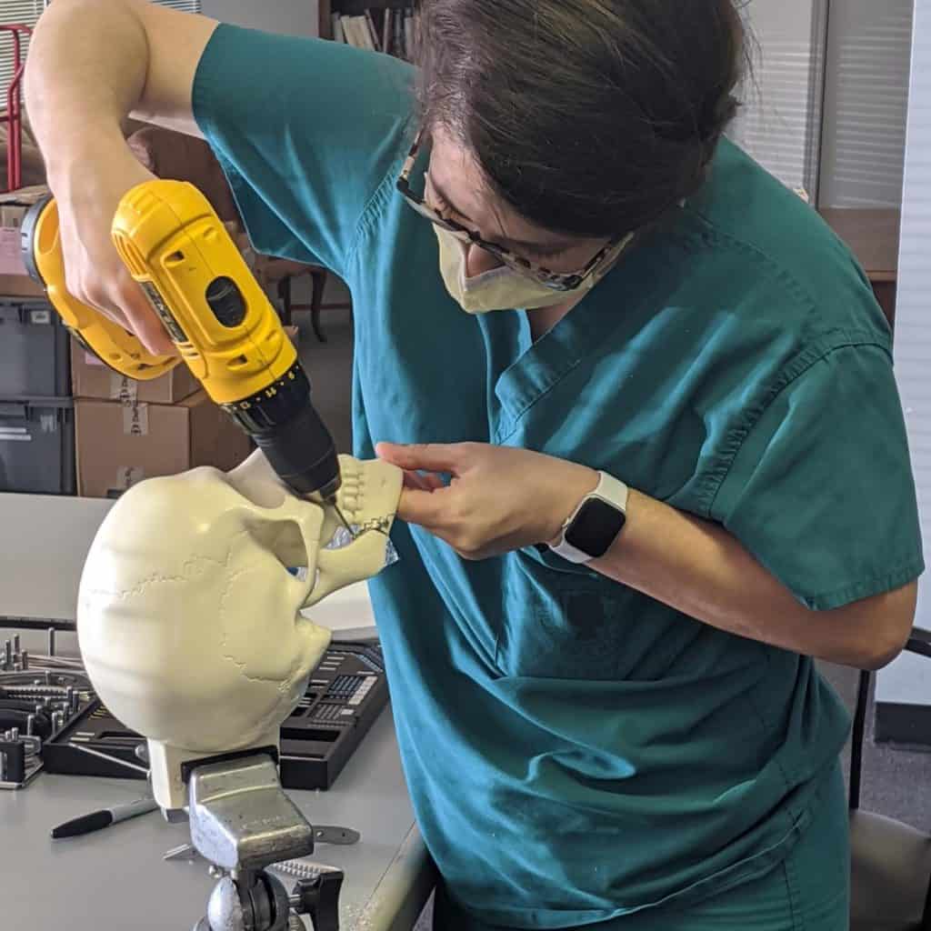 Resident drilling into a skull model