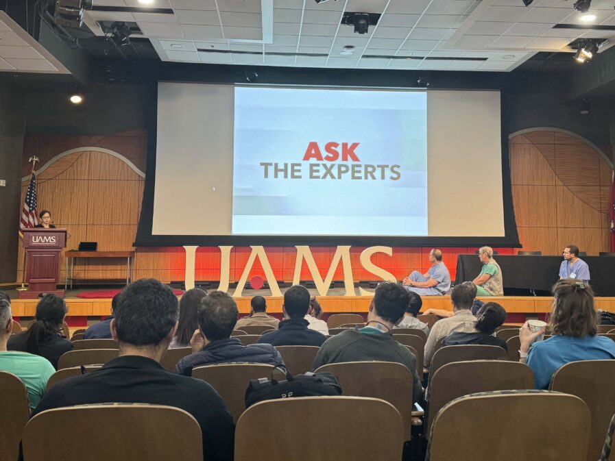 People in an auditorium listening to a panel discussion