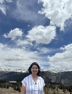 Bhawana Adhikari standing outdoors with snow-covered mountains in the background