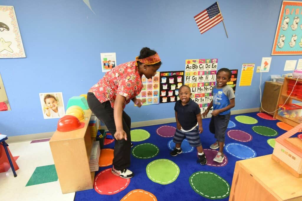 Children play and learn with a worker at the Dennis Developmental Center.