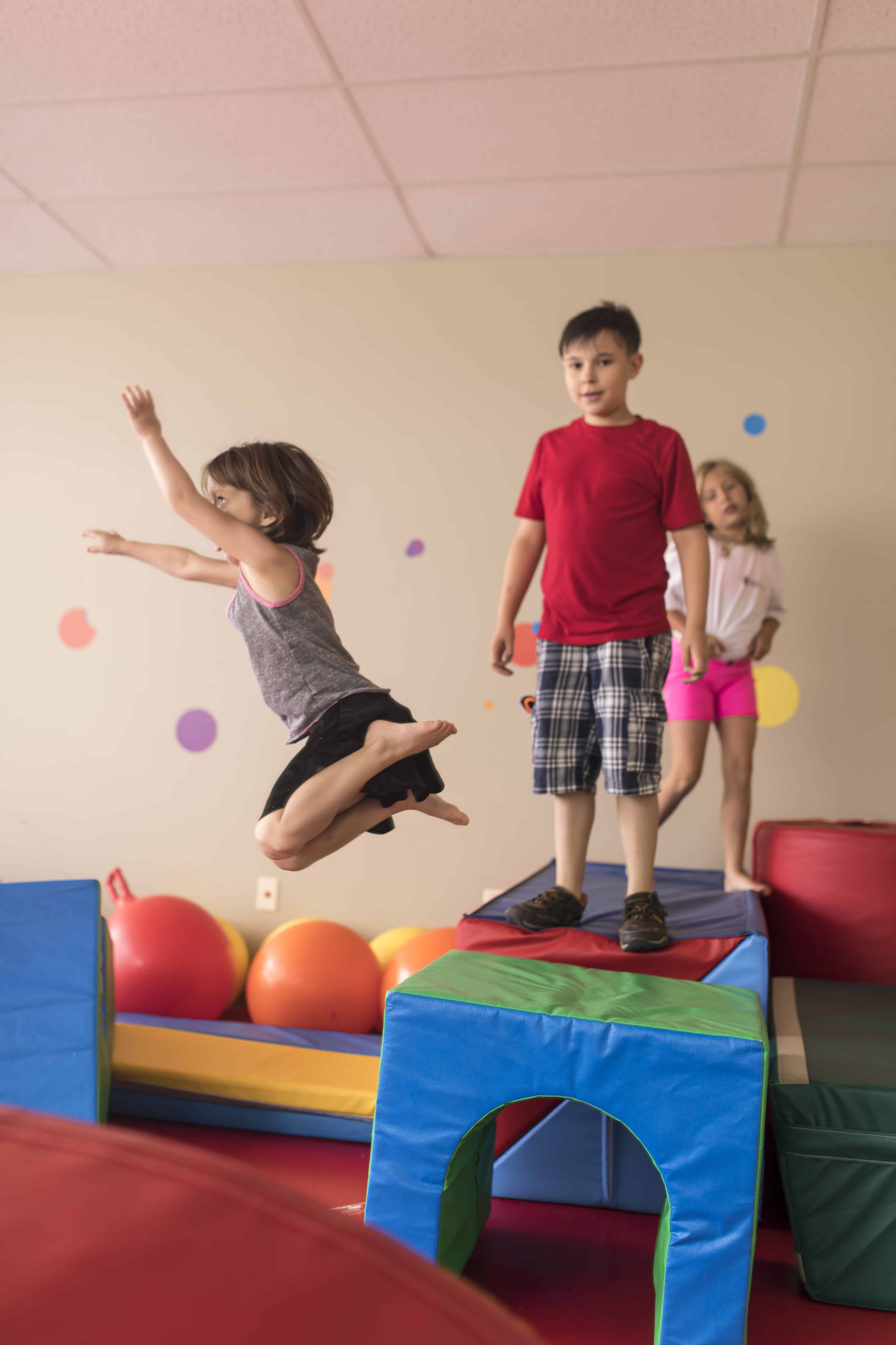 kids in colorful play room queued up to jump