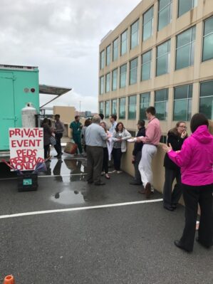 Residents enjoy lunch at a food truck on the top of a parking deck