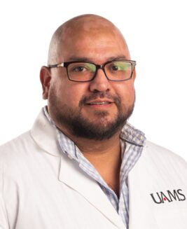 Manuel Martinez, postdoctoral fellow, wearing a UAMS labcoat