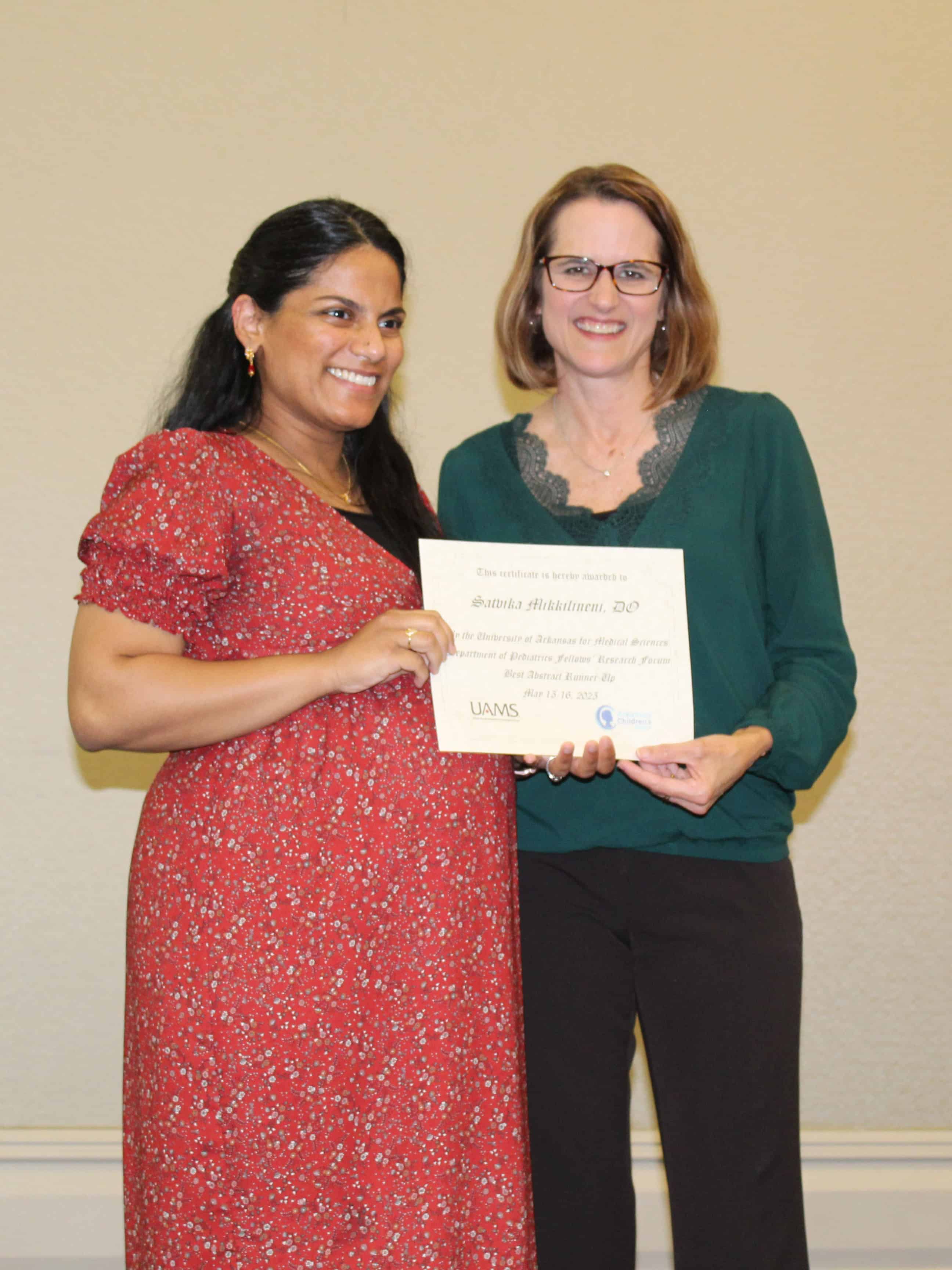 Dr. Jill Fussell presents the Best Abstract Runner Up, Dr. Satvika Mikkilineni, with a certificate