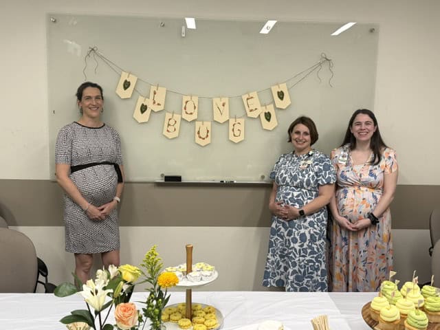 ID Faculty and staff in front of a baby shower sign