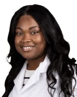 Portrait of a young female research associate smiling for a professional photo in a lab coat.
