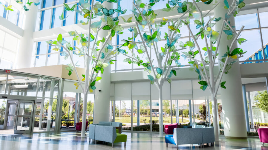The remodeled patient entrance at Arkansas Children's Hospital features art installations of white trees with colorful butterflies on the branches