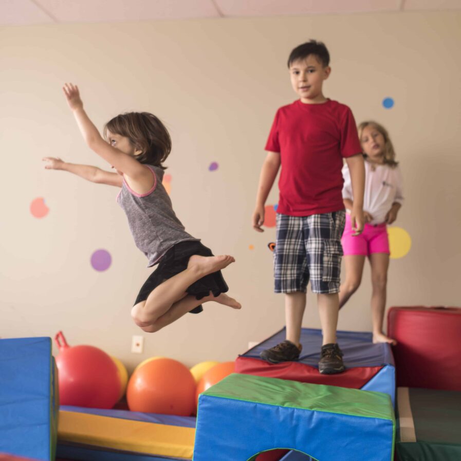 kids in colorful play room queued up to jump