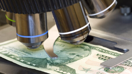 A microscope examines a fifty-dollar bill
