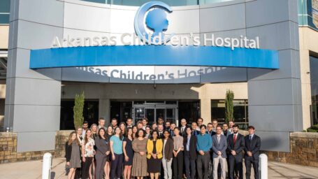 UAMS pediatric fellows pose for a group photo in front of the main entrance to Arkansas Children's Hospital