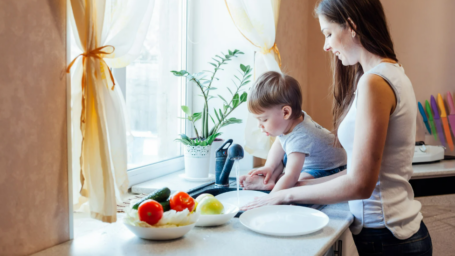 mom and child washing vegetables in the sink