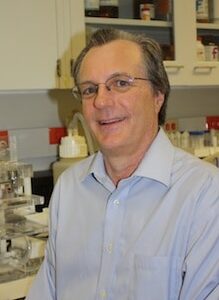 Prather in his lab in front of multiple lab instruments