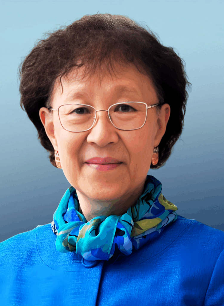 headshot of Dr. Ho. in front of a blue background with a dark blue blazer and scarf on