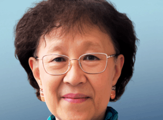 Shuk-Mei Ho, Ph.D. headshot of Dr. Ho. in front of a blue background with a dark blue blazer and scarf on