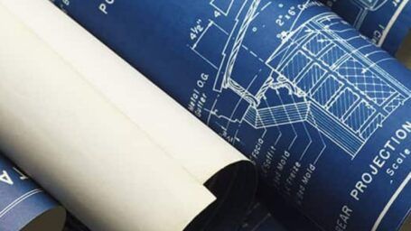 several rolled blueprints that depict office spaces