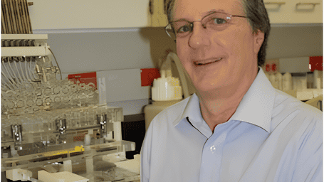 Prather in his lab in front of multiple lab instruments