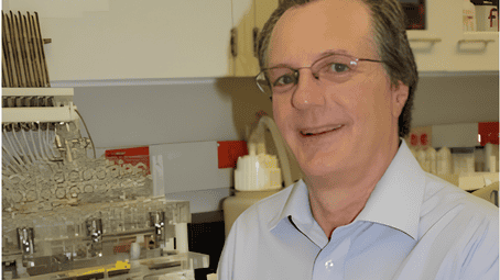 Prather in his lab in front of multiple lab instruments